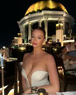 Woman in a white strapless dress at an outdoor restaurant.