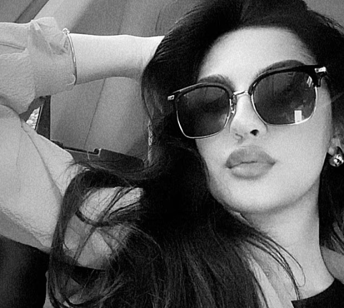 Black and white photo of a woman wearing sunglasses.