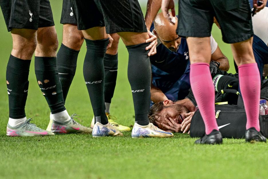 James Maddison injured on the field, surrounded by teammates and medical staff.