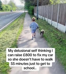 A child walking a dog on a sidewalk next to a road.