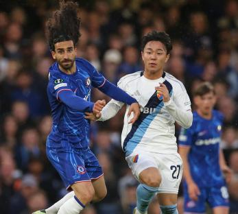 Marc Cucurella of Chelsea challenged for the ball by Keita Kosugi of Djurgarden during a soccer match.