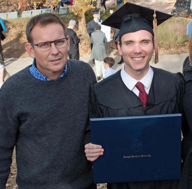 Professional pilot Tim Lilley with his son Sam Lilley, who is wearing a graduation cap and gown.