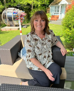 Lorraine Kelly sitting in a garden chair.