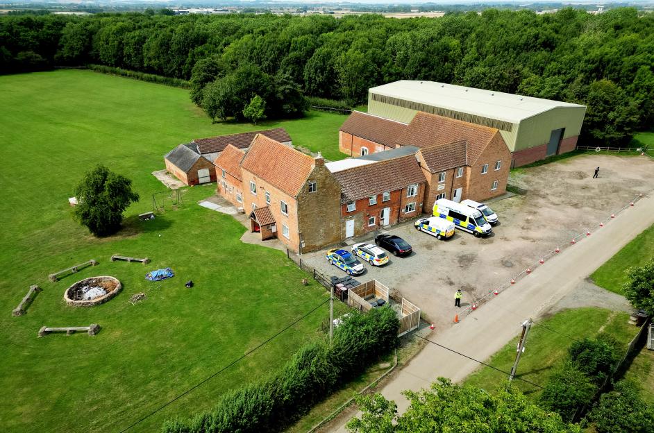 Aerial view of Stathern Lodge, a crime scene with police cars and officers present.