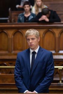 Man in a suit in a courtroom.