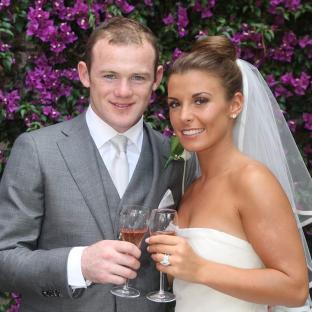 Wayne Rooney and Coleen Rooney toasting with champagne on their wedding day.