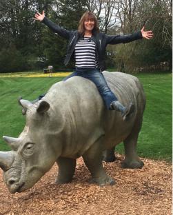 Woman sitting on a rhino statue.