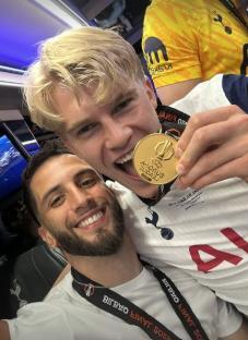 Two Tottenham Hotspur players celebrating with a Europa League medal.