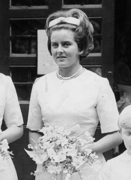 Lady Henrietta Guinness at a wedding, holding a bouquet of flowers.