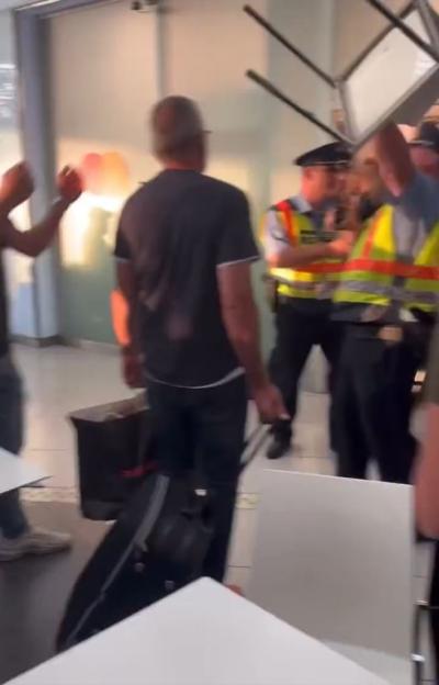 Anthony Taylor (center, back to camera) with police officers and overturned chairs.