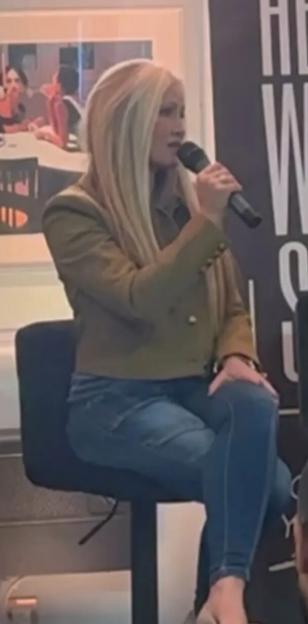 Caprice Bourret speaking into a microphone while seated.