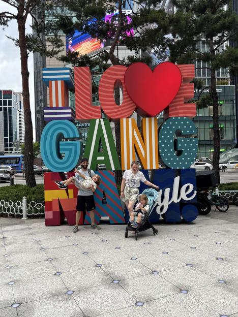Family posing in front of a "I Love Gangnam" sign in South Korea.