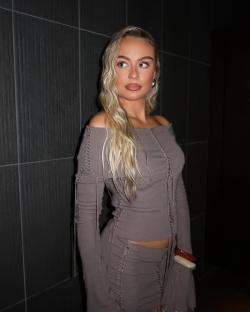 Woman in brown off-the-shoulder outfit.