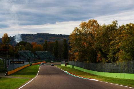 Autodromo Enzo e Dino Ferrari race track with two cars driving on it.