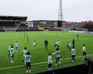 Tottenham Hotspur players warming up on a soccer field.