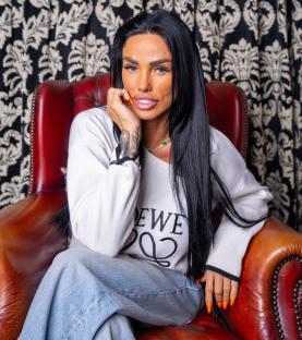 Katie Price sitting in a leather chair.