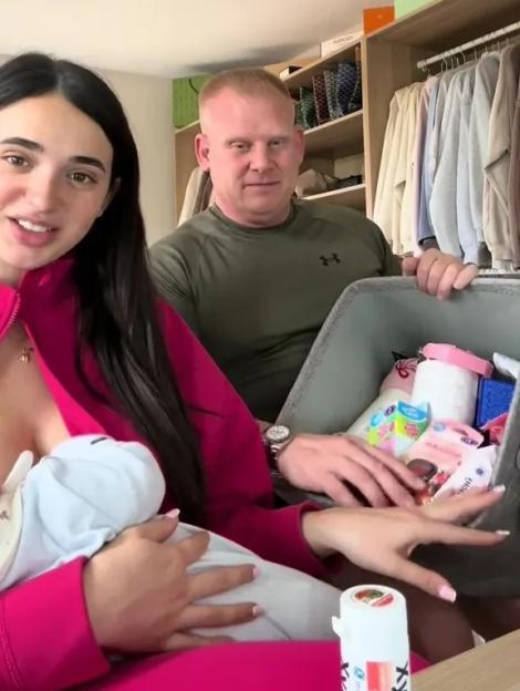 Couple with baby and basket of baby products.