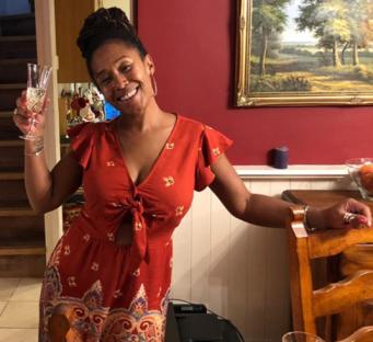 Photo of Bibaa Henry holding a glass of champagne.