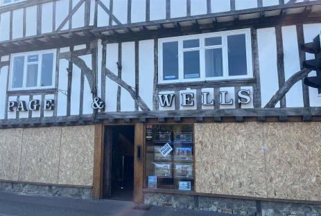Boarded-up storefront of Page & Wells estate agents.