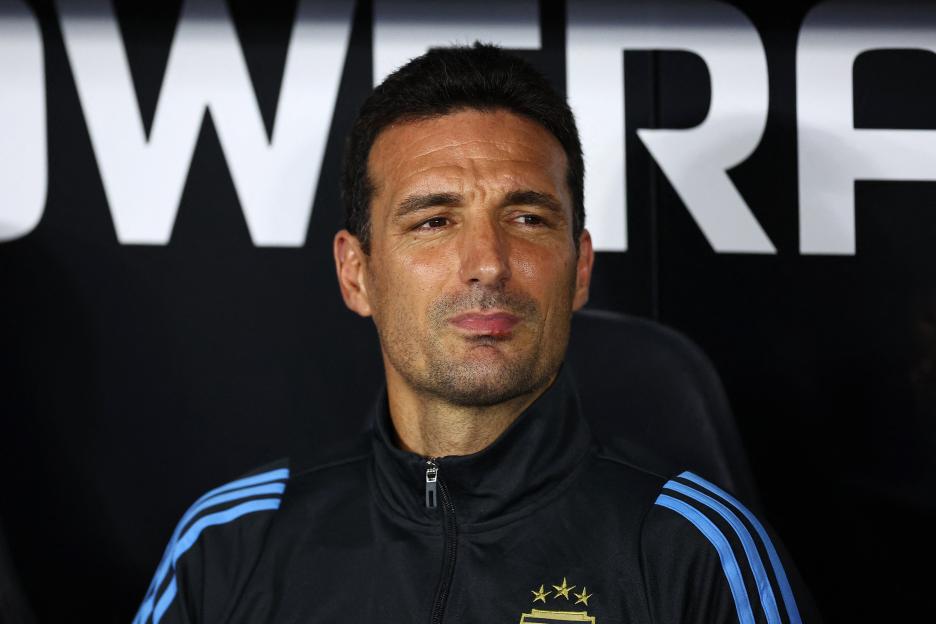 A man wearing a black adidas jacket with blue stripes.