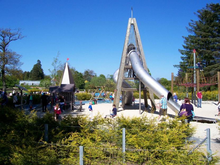 Children playing on a playground with a large metal slide.