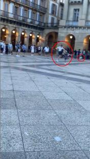 Video still of Tottenham and Manchester United fans arguing and kicking a football at each other in a plaza.