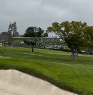 Small plane landing on a golf course.