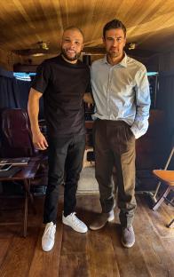 Chris Eubank Jr. and another man posing for a photo on a film set.