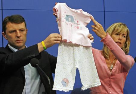 Parents of Madeleine McCann holding up their daughter's pajamas at a press conference.