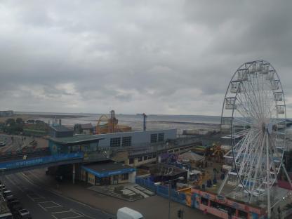 Aerial view of Southend Pier on an overcast day, featuring a Ferris wheel and amusement park rides.