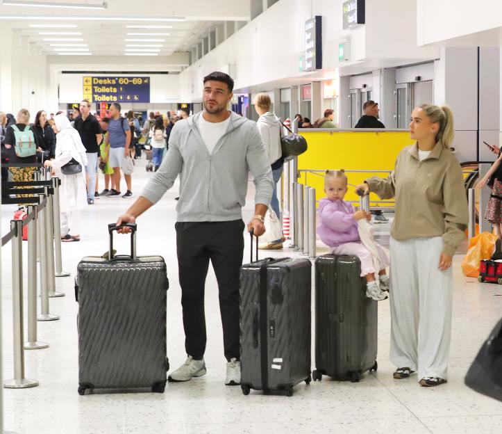 Molly-Mae Hague, Tommy Fury, and their daughter at an airport.