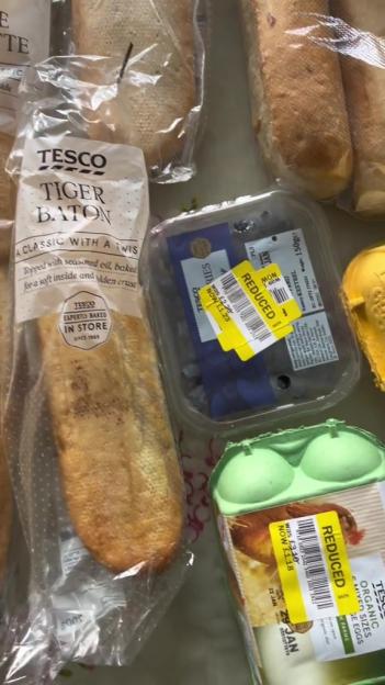 Reduced-price groceries including bread, blueberries, and eggs.