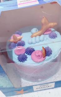Mermaid-themed cake decorated with frosting and gold accents.