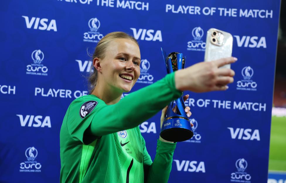 Hannah Hampton taking a selfie with her VISA Player of the Match trophy.
