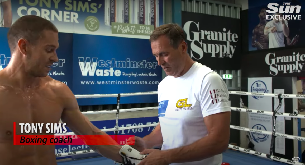 Boxing coach Tony Sims wrapping a boxer's hand.