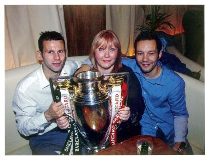 Ryan Giggs with his mother and brother holding a Premiership trophy.