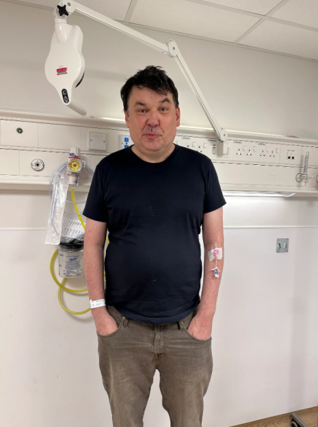 Graham Linehan in a hospital room with an IV in his arm.