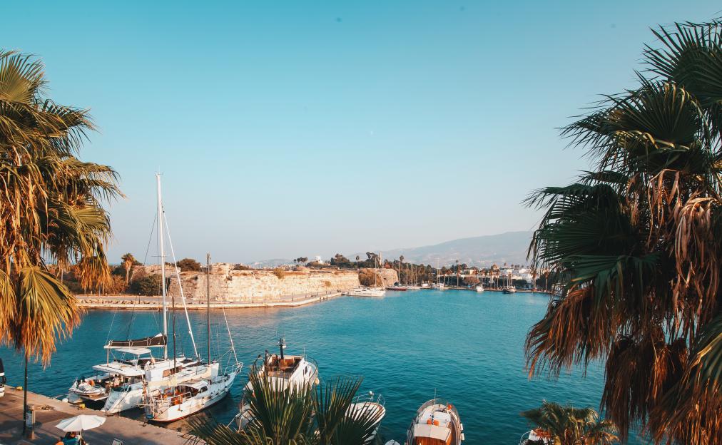 Kos, Greece harbor view with boats and a fort.