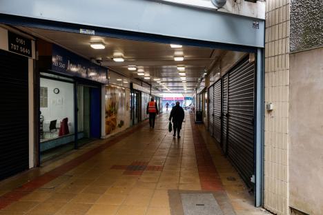 Pedestrians walking through a nearly empty shopping arcade.