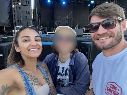 Photo of a woman and two men at a music festival.