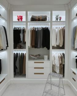 Large walk-in closet with clothing and accessories.