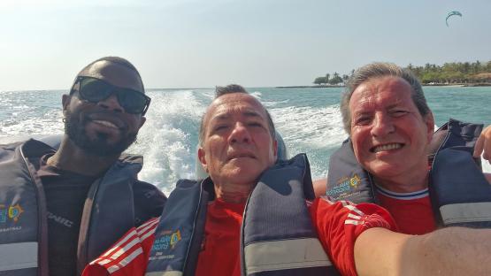 Three men in life vests on a boat.