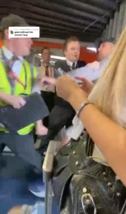 Airport worker removing an abusive passenger from a plane.