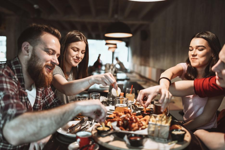 Happy friends sharing a meal at a restaurant.