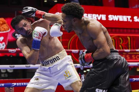 Devin Haney landing a punch on Jose Ramirez during a boxing match.