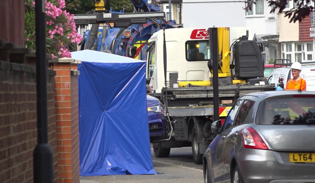 Crime scene in Monks Park, Wembley, with a blue tarp covering part of the scene.