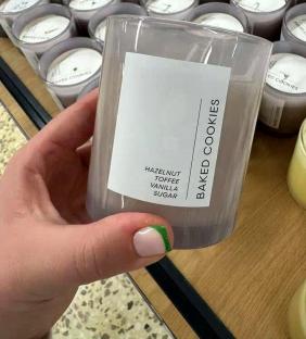 Hand holding a Tesco Baked Cookies candle.
