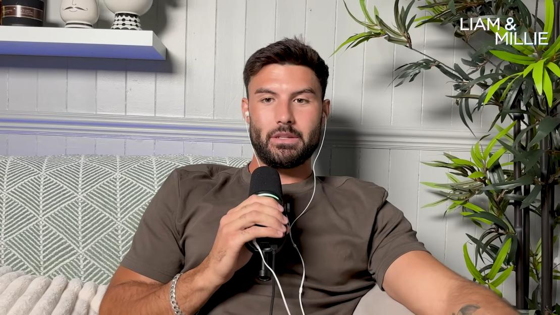 Liam Reardon discusses break-ups on a podcast, holding a microphone.