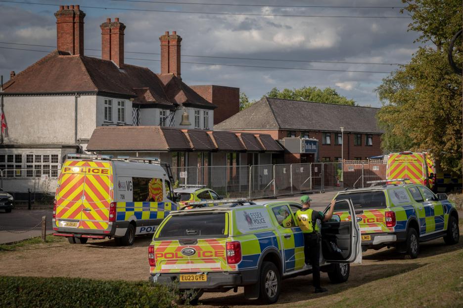 Essex Police vehicles outside a hotel during a protest.