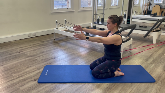 Woman doing Pilates leg exercises with resistance bands.